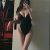 Woman in a black one-piece swimsuit posing for a mirror selfie, with a mural visible on the left in the room. Woman in a black one-piece swimsuit posing for a mirror selfie, with a mural visible on the left in the room.