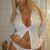 Woman in an open white button-down shirt with visible cleavage, wearing white underwear in a tiled bathroom setting.